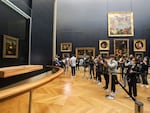 A visitor photographs the painting the Mona Lisa by Italian artist Leonardo Da Vinci on display in a gallery at the Louvre on May 19, 2021 in Paris.