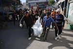 Residents and members of a civil defense team conduct search and rescue operations after the Israeli army targeted Asma School, run by the United Nations agency that aids Palestinians in the Shati refugee camp in Gaza Strip on Sunday. The wounded, including children, were brought to Shifa Hospital in Gaza City. The bodies of those who lost their lives were also brought to the hospital.