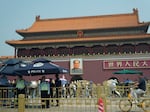 Police officers watch over Tiananmen Gate on Tuesday in Beijing. As Beijing's toughened political stance effectively extinguished any large-scale commemorations within its borders, overseas commemorative events have grown increasingly crucial for preserving memories of the Tiananmen crackdown.