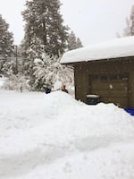 The snow piles high in Bend where a man shovels his driveway.