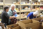Gladstone Food Pantry staff and volunteers organize food for distribution at the pantry's reopening at Kraxberger Middle School on Oct. 8, 2025, in Gladstone, Ore.