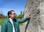 Weston Koyama examines the names of wartime concentration camps engraved on a rock displayed at the Japanese American Historical Plaza in Portland, Ore., on April 22, 2024.