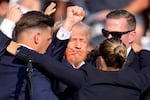 Republican presidential candidate former President Donald Trump is helped off the stage by U.S. Secret Service agents at a campaign event in Butler, Pa., on Saturday, July 13, 2024.