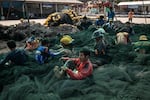 Fishermen mend nets in Samut Sakhon, Thailand, on Wednesday, January 15, 2025.