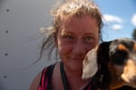 Chantel Helwig, 44, holds her dog, Odin. Helwig is seeking refuge from the Darlene 3 fire at the La Pine High School on June 26, 2024 in La Pine, Ore. Helwig says water, food and sanitation bags for pets are a few of the many needs.