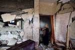 A woman stands in her damaged house in Rafah, in the southern Gaza Strip, on Friday, following Israeli bombardment amid continuing battles between Israel and the Palestinian militant group Hamas.