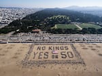 This aerial picture shows protesters forming a human banner during the "No Kings" national day of protest on Ocean Beach in San Francisco, Calif. on Oct. 18, 2025.