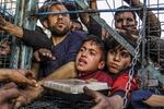 Crowds of hungry Palestinian adults and children wait to receive food distributed by charity organizations amid Israel's blockade as the situation dramatically deteriorates in Jabaliya refugee camp, Gaza, on March 27.