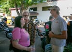 Thor Drake, right, founder of One Moto Cafe in Portland, Ore., talks to Sandie Simone, left, and Jeffrey Meyers at the cafe's grand opening party on July 26, 2024. The cafe was filled with people, many of whom have supported Drake's work and gathered in this building for years. 