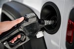 A man uses a gas pump at a Shell gas station in Houston.