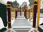 The bridge of a playground structure at a public park has ice on it.