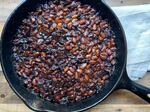 Blackberry baked beans in a cast iron pan.