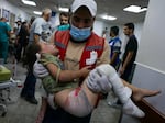 An emergency responder carries a wounded child in a hospital following Israeli airstrikes in Rafah, southern Gaza Strip, on Friday.