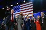 President-elect Donald Trump gestures as he walks with former first lady Melania Trump at an election night watch party at the Palm Beach Convention Center, Wednesday, Nov. 6, 2024, in West Palm Beach, Fla.