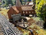 Alan Olson displays a scale replica of a historic church that once stood on Mount Hood, built in the 1930s by Oregon's famous cabin craftsman, Henry Steiner.