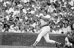 Chicago Cubs ' Ryne Sandberg slugs a triple during Wednesday, Aug. 29, 1984 game against the Cincinnati Reds in Chicago.