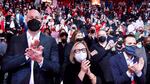 Portland Trail Blazers interim general manager Joe Cronin, left, team owner Jody Allen, center, and president of business operations Dewayne Hankins, right, all wearing masks, clap during player introductions before an NBA basketball game against the Oklahoma City Thunder in Portland, Ore., Friday, Feb. 4, 2022.