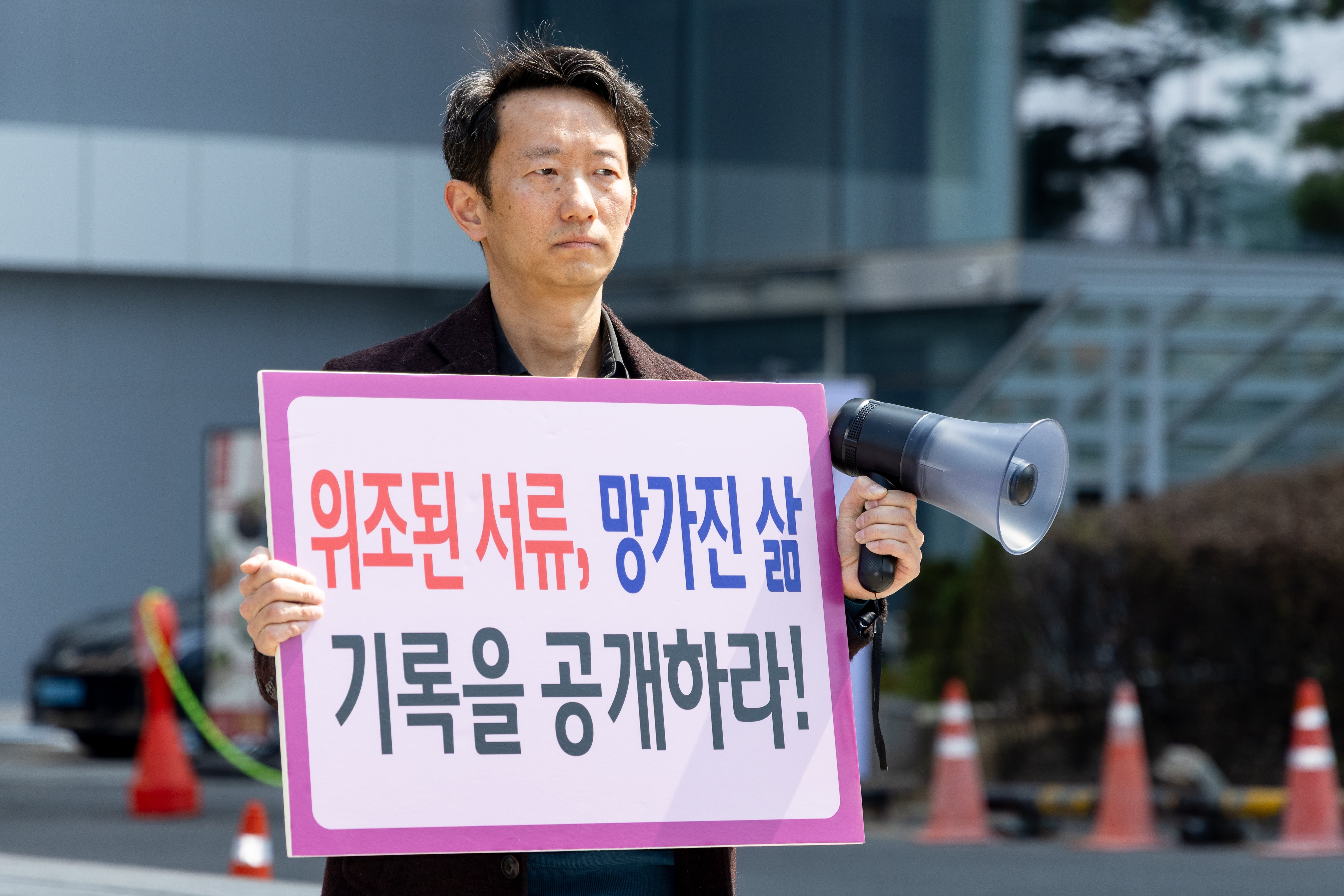 Jonggeun Song, born in 1979 and adopted in the Netherlands at age 4, stages a one-person protest in front of the Korea Child Rights Protection Agency in Seoul, South Korea, on April 1. He holds a sign that reads, ''Forged Documents, Broken Lives, Release the Records.'' He calls for the disclosure of overseas adoption records and an end to international adoptions.