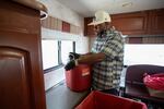 Pierson disposes a container full of used needles into a cardboard box lined with a biohazard bag to get destroyed.