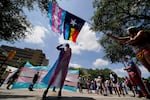 Demonstrators gather on the steps to the Texas Capitol and wave flags while speaking against transgender-related legislation bills being considered in the Texas Senate and House in 2021, in Austin, Texas.