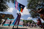 Demonstrators gather on the steps to the Texas Capitol and wave flags while speaking against transgender-related legislation bills being considered in the Texas Senate and House in 2021, in Austin, Texas.