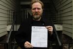 Navy Veteran Scottie Carpenter holds his notice of no-cause eviction.