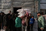 Palestinians receive bags of flour and other humanitarian aid distributed by UNRWA, the U.N. agency helping Palestinian refugees, in Jabaliya, Gaza Strip, on Tuesday.