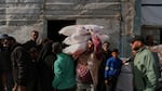 Palestinians receive bags of flour and other humanitarian aid distributed by UNRWA, the U.N. agency helping Palestinian refugees, in Jabaliya, Gaza Strip, on Tuesday.