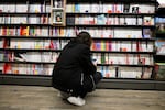 A woman looks at books in a library in 2024.