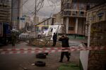 Police officers inspect area after an apparent Russian strike in Kyiv Ukraine, Thursday, Feb. 24, 2022. Russian President Vladimir Putin on Thursday announced a military operation in Ukraine and warned other countries that any attempt to interfere with the Russian action would lead to "consequences you have never seen."