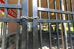 A sturdy metal fence and locked gate at Stillman Park in Pendleton, Ore., keeps people out of a picnic shelter on May 3, 2026.
