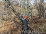 Biologist Lance Wyss points at the riparian forest they've restored near the creek. The entire area behind him was filled with invasive blackberry bushes.