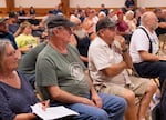 From left, town residents Paul Britt and Carl Campbell attend a fire information meeting in Fossil, Ore., on Tuesday, July 21, 2026.