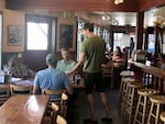 Old Schoolhouse Brewery owner Jacob Young serves food to his customers. He says when there's little smoke and fires are far away, he sees more patrons.