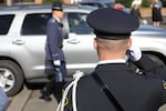 A law enforcement agent salutes a vehicle carrying family of slain Seaside Police Sgt. Jason Goodding.