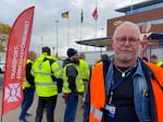Goran Larsson, a cargo ship inspector, poses next to the Transport Workers' Union flag at the Malmo port on Nov. 7. Dockworkers are refusing to load or unload Teslas at this port and all others across the country.