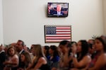 A recorded video message by then-President Donald Trump plays at a 2019 naturalization ceremony for new U.S. citizens at the U.S. Citizenship and Immigration Services field office in Miami.