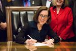 Oregon Gov. Kate Brown signs a bill into law to increase the state minimum wage in March 2016.