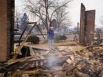 A woman reacts to seeing the remains of her mother's home destroyed by the Marshall Wildfire in Louisville, Colo., in 2021. A new survey finds that most Americans say they have experienced extreme weather in the last five years.