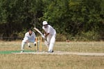 A player bats for Multnomah Cricket Club. Cricket is similar to baseball, but has two batsmen, a bowler instead of a pitcher, and two wickets instead of four bases.
