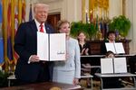 President Donald Trump holds up a signed executive order alongside Secretary of Education Linda McMahon in the East Room of the White House in Washington, Thursday, March 20.