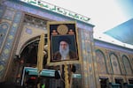 Pilgrim carries a portrait of Iran's Supreme Leader, Ali Khamenei, outside the Imam Hussein Shrine in Karbala during the Arbaeen pilgrimage.