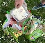 A shopper at an Urban Gleaners Free Food Market in Lents Park goes through his market haul on May 25, 2023, in Portland, Ore.