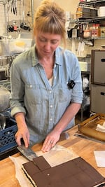 Owner Kate McMillen cuts Nanaimo bars at the kitchen of Lauretta Jean's bakery in Portland, Ore., on May 27, 2026.
