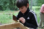 Julius Samiee, one of David's students, examines the dirt archeologists are sifting through for clues to the origin of the bifaces. 