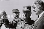Bosnian Serb General Ratko Mladic (center) speaks with Bosnian Serb President Radovan Karadzic (right) in the Bosnian town of Banja Luka, in 1994.