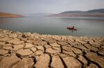 FILE - A kayaker paddles in Lake Oroville as water levels remain low due to continuing drought conditions in Oroville, Calif., on Aug. 22, 2021. The American West's megadrought deepened so much last year that it is now the driest it has been in at least 1200 years and a worst-case scenario playing out live, a new study finds.
