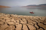 FILE - A kayaker paddles in Lake Oroville as water levels remain low due to continuing drought conditions in Oroville, Calif., on Aug. 22, 2021. The American West's megadrought deepened so much last year that it is now the driest it has been in at least 1200 years and a worst-case scenario playing out live, a new study finds.