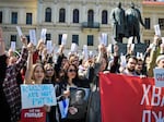 People hold sheets reading "enough" as they protest in downtown Tbilisi, Georgia, on Sunday.