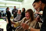 Retired stylist Derek Thompson, right, holds up a mirror to show Debbie her new haircut. Thompson's organization Hands of Favor provides free hair cuts and styling to the homeless. 